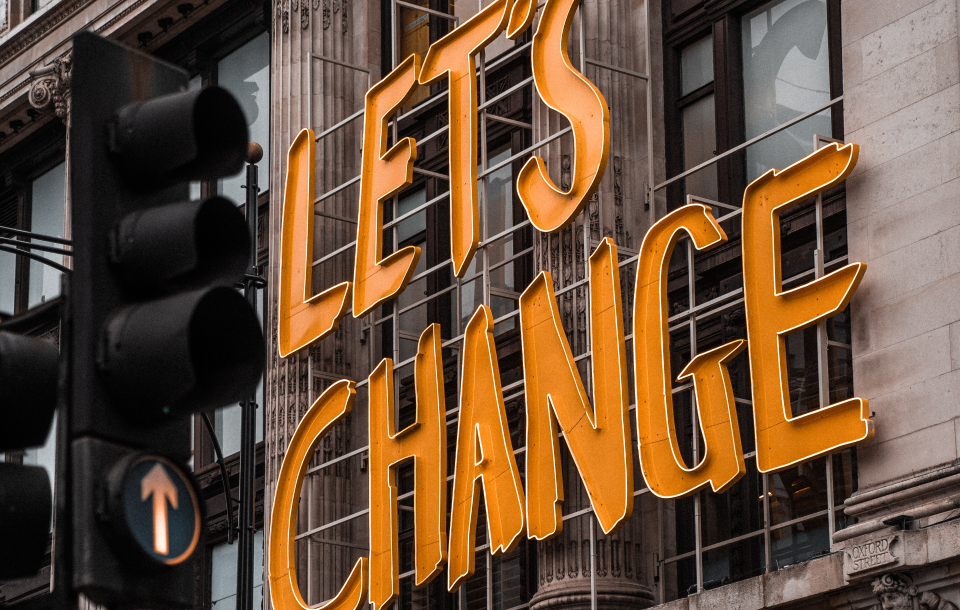 A sign outside a building that says 'Let's Change'.